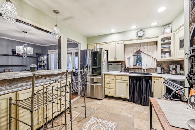 kitchen with sink, tasteful backsplash, a notable chandelier, pendant lighting, and appliances with stainless steel finishes