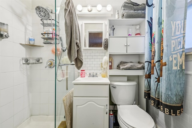 bathroom featuring toilet, a tile shower, vanity, and tasteful backsplash