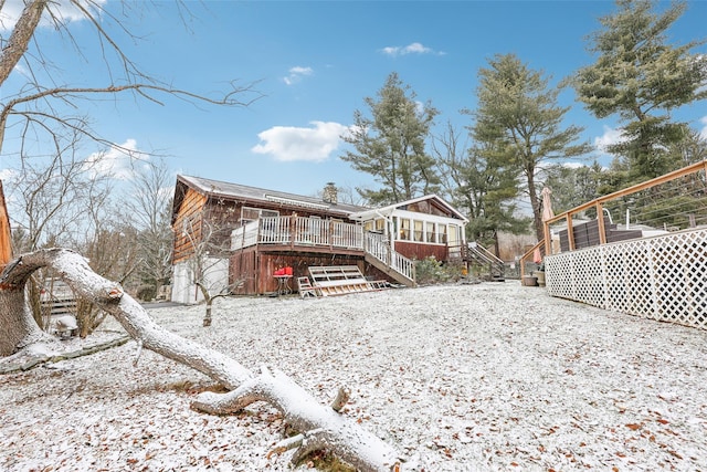 snow covered rear of property with a deck