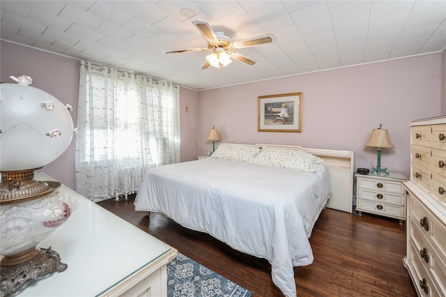 bedroom with dark hardwood / wood-style flooring and ceiling fan