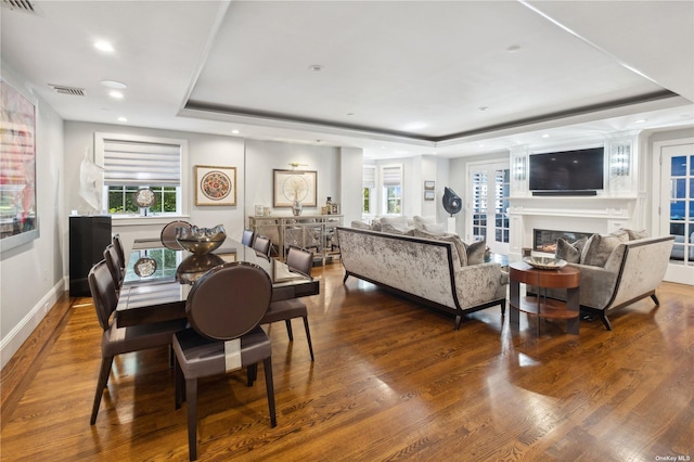 dining room featuring hardwood / wood-style flooring and a raised ceiling