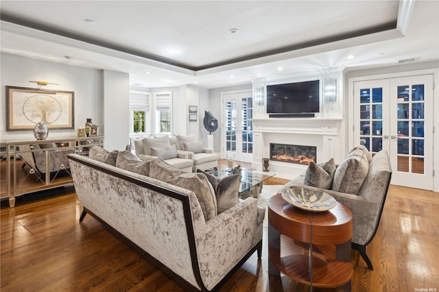 living room featuring a raised ceiling, french doors, and wood-type flooring