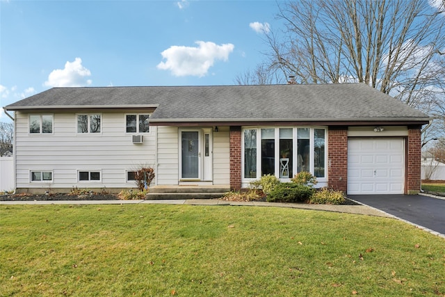 tri-level home with a garage, a shingled roof, aphalt driveway, and a front yard