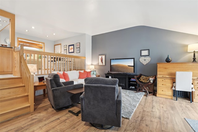 living room with light wood-type flooring and vaulted ceiling