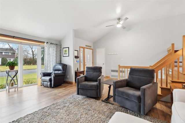 living room with radiator, light hardwood / wood-style floors, vaulted ceiling, and ceiling fan