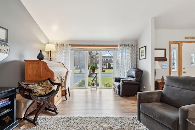 sitting room with lofted ceiling and light wood-type flooring