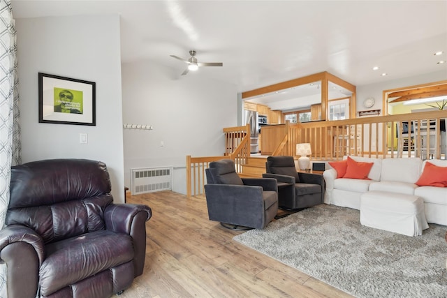 living room featuring light wood-type flooring, radiator, and ceiling fan