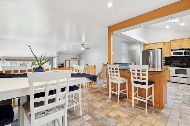 kitchen featuring appliances with stainless steel finishes, tasteful backsplash, a kitchen island, and lofted ceiling