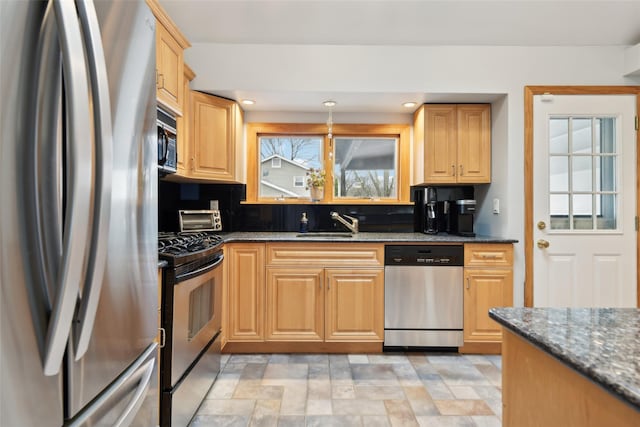 kitchen with dark stone counters, sink, and black appliances