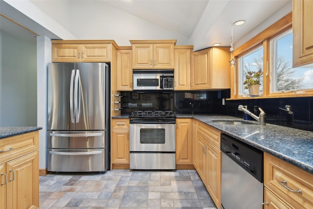 kitchen featuring sink, vaulted ceiling, dark stone countertops, tasteful backsplash, and stainless steel appliances