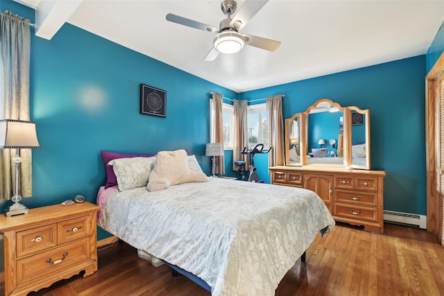 bedroom featuring ceiling fan, wood-type flooring, and a baseboard heating unit