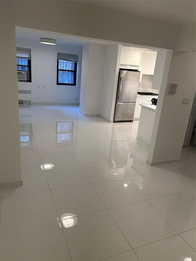 interior space with cooling unit, light tile patterned floors, and radiator