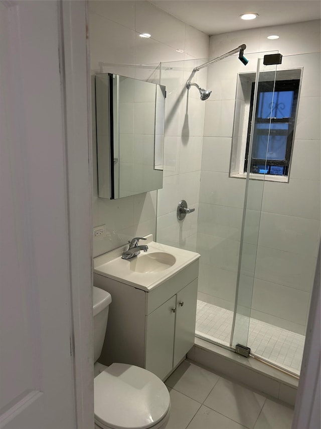 bathroom with tile patterned flooring, vanity, toilet, and an enclosed shower