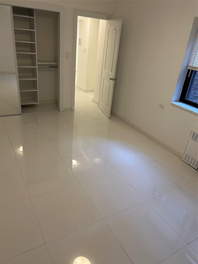 unfurnished bedroom with light tile patterned floors and a closet