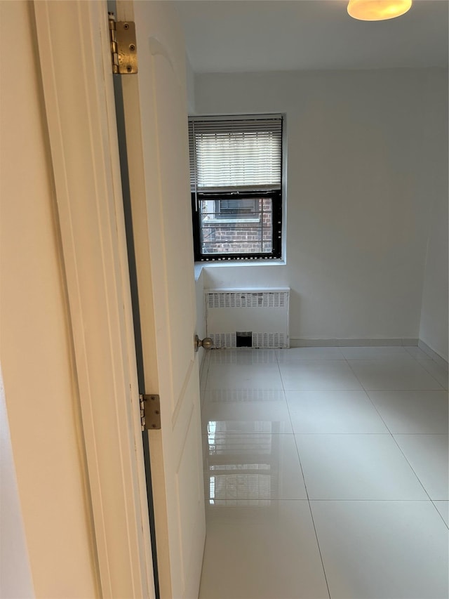 empty room with tile patterned floors and radiator