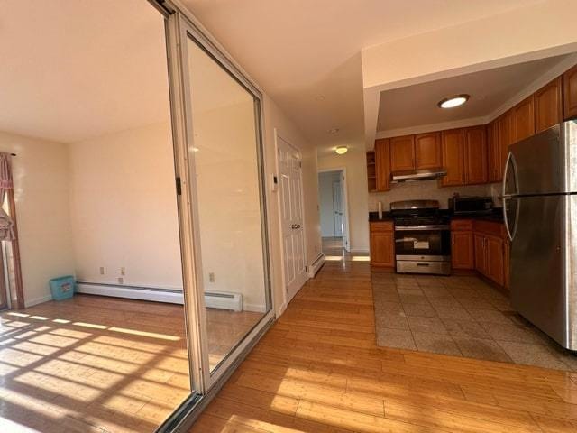 kitchen featuring light hardwood / wood-style flooring, appliances with stainless steel finishes, and a baseboard heating unit