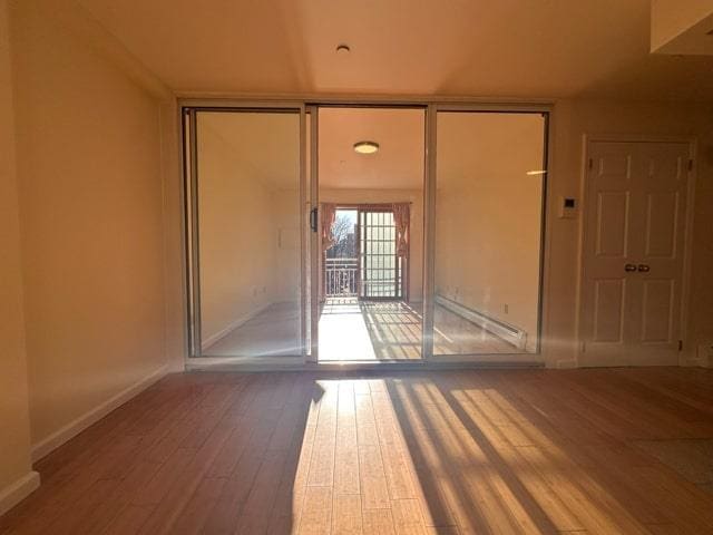 empty room featuring expansive windows and wood-type flooring