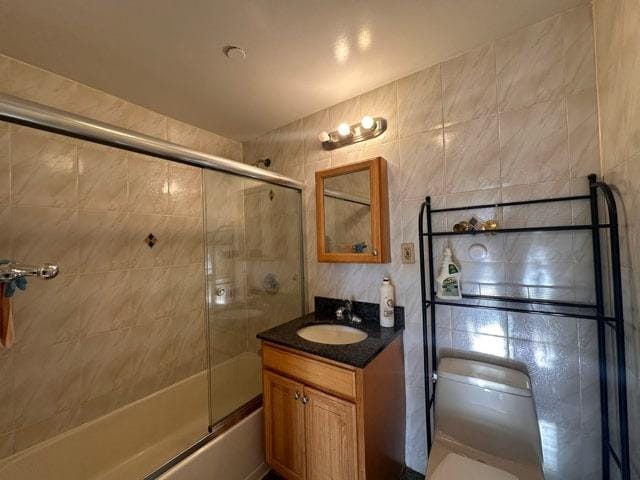 full bathroom featuring toilet, vanity, and combined bath / shower with glass door