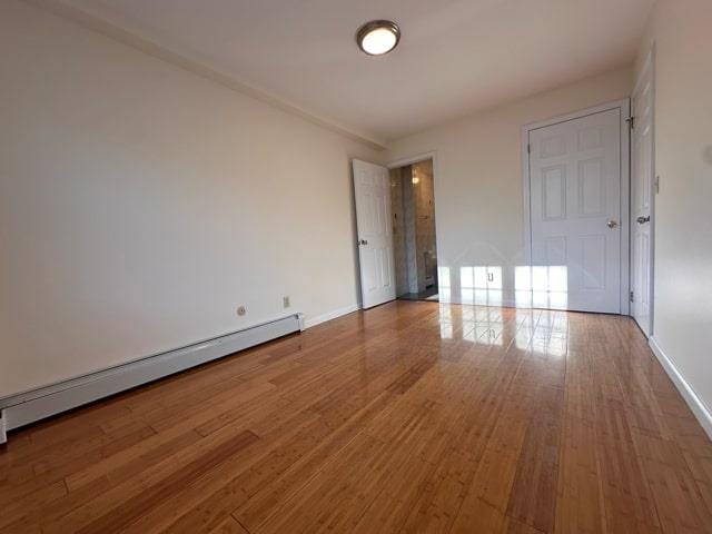 interior space with wood-type flooring and baseboard heating