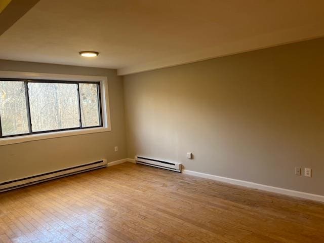 empty room with light wood-type flooring and baseboard heating