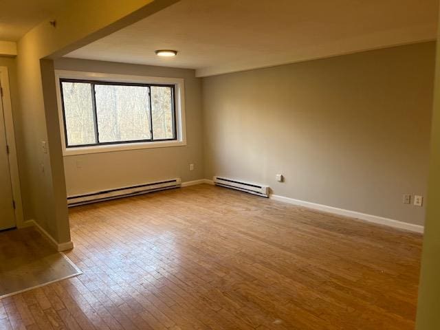 spare room featuring light wood-type flooring and a baseboard heating unit