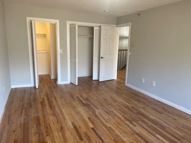 unfurnished bedroom featuring a closet and dark wood-type flooring