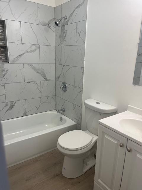 full bathroom with hardwood / wood-style floors, vanity, toilet, and tiled shower / bath combo