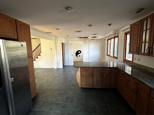 kitchen featuring kitchen peninsula and stainless steel refrigerator