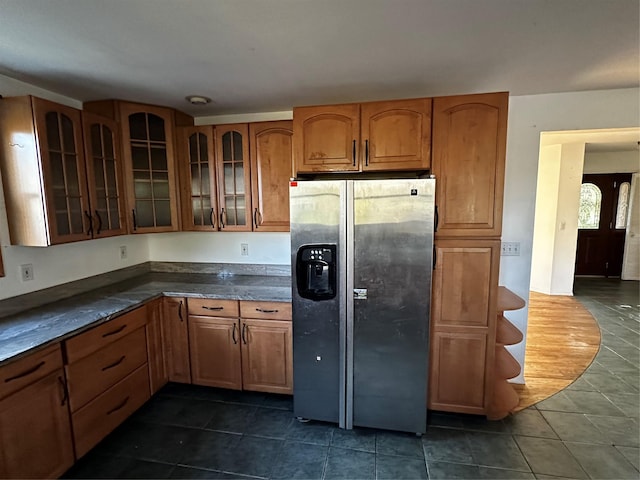 kitchen featuring dark tile patterned flooring and stainless steel fridge