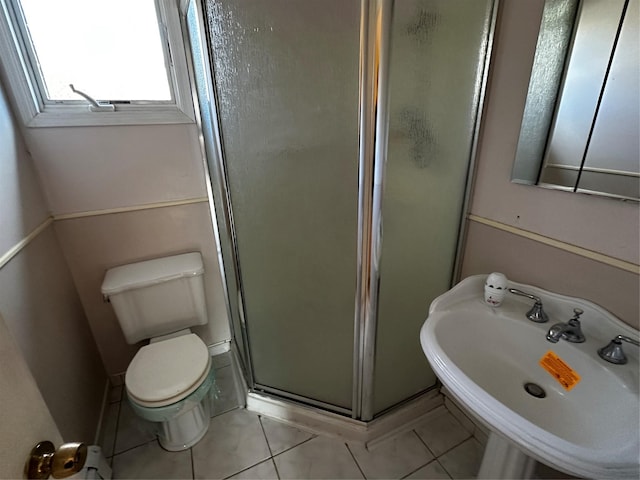 bathroom with tile patterned floors, toilet, sink, and walk in shower