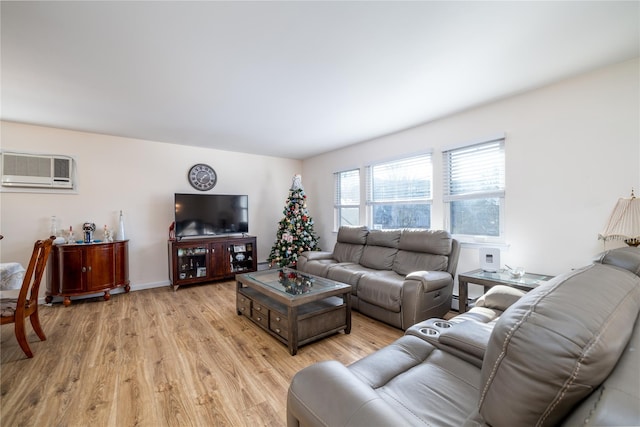 living room with an AC wall unit and light hardwood / wood-style flooring