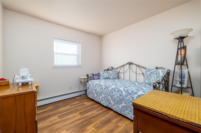 bedroom featuring dark hardwood / wood-style floors and a baseboard heating unit