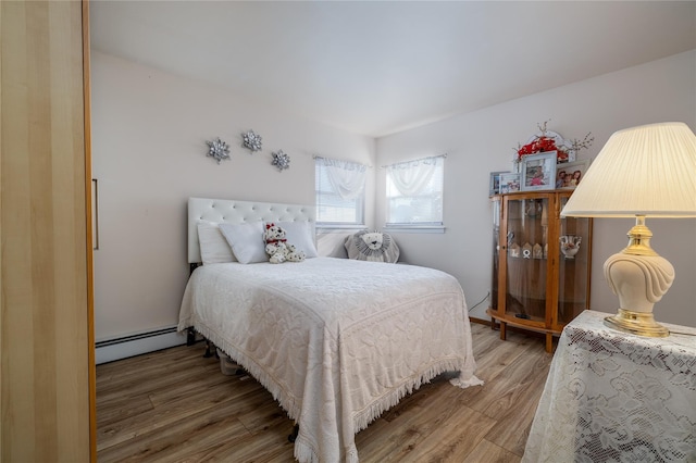 bedroom featuring hardwood / wood-style floors and baseboard heating