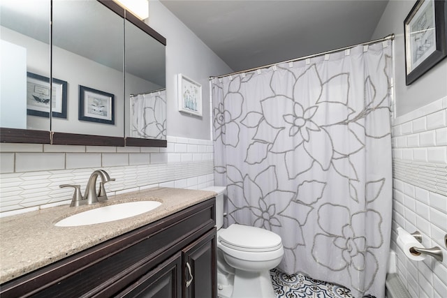 bathroom featuring a shower with shower curtain, vanity, tile walls, tile patterned flooring, and toilet