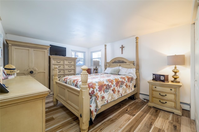 bedroom featuring light wood-type flooring and baseboard heating