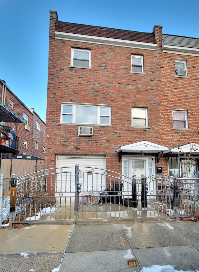 view of property with a wall mounted air conditioner and a garage