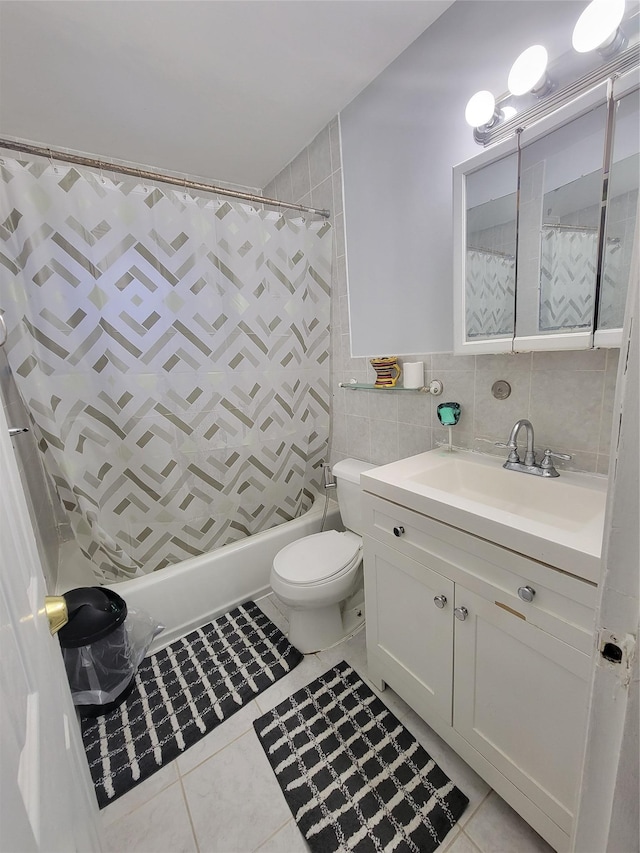 bathroom with tile patterned floors, vanity, tile walls, and toilet