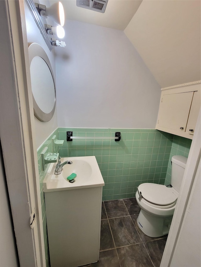 bathroom featuring tile patterned flooring, vanity, tile walls, and toilet