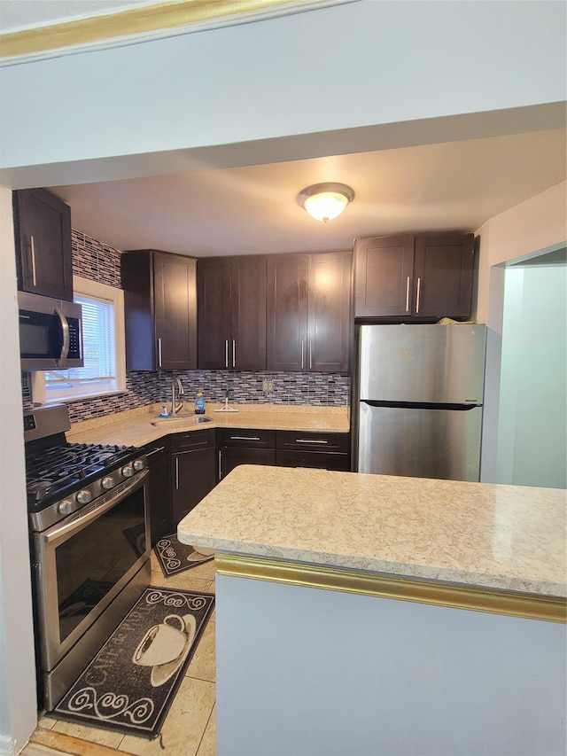 kitchen with decorative backsplash, dark brown cabinetry, stainless steel appliances, and sink