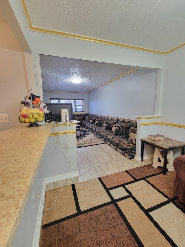 interior space with crown molding, a textured ceiling, and light wood-type flooring