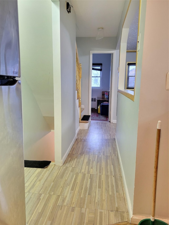 hallway with radiator and light hardwood / wood-style flooring