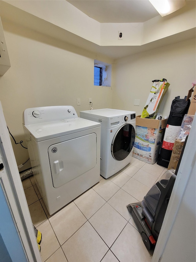 laundry area featuring washer and dryer and light tile patterned floors