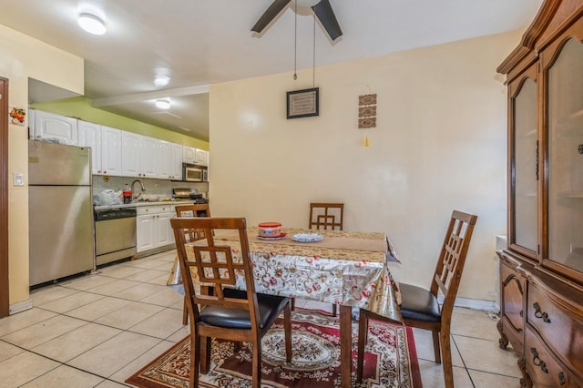 tiled dining area with ceiling fan and sink