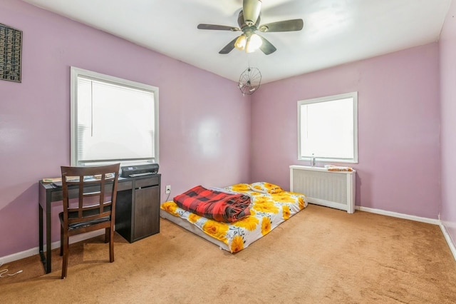 carpeted bedroom featuring ceiling fan and radiator heating unit