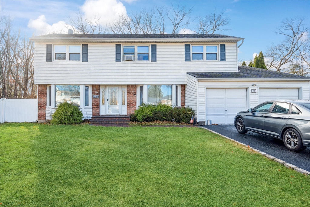 view of property with a front lawn and a garage