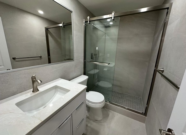 bathroom with backsplash, toilet, a shower with door, vanity, and tile walls