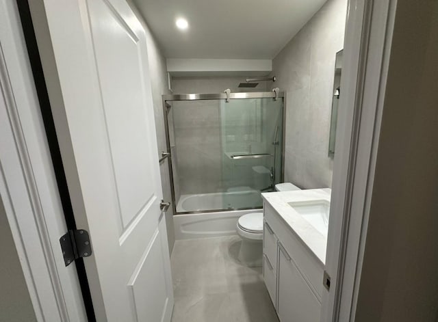 full bathroom featuring vanity, toilet, and shower / bath combination with glass door