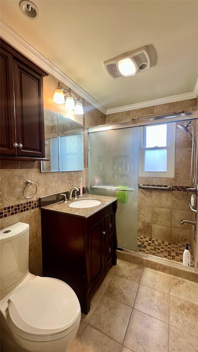 bathroom featuring vanity, toilet, a shower with door, and crown molding