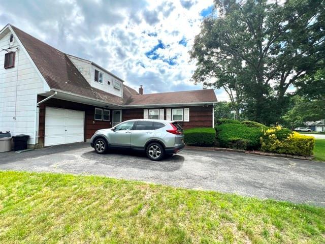 view of front of property with a garage and a front lawn