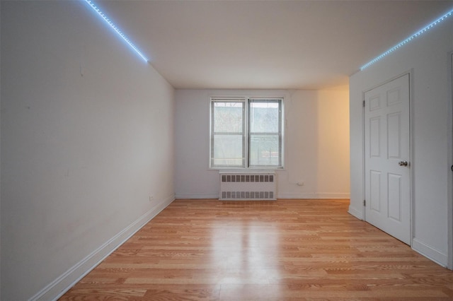 unfurnished room featuring light hardwood / wood-style flooring and radiator